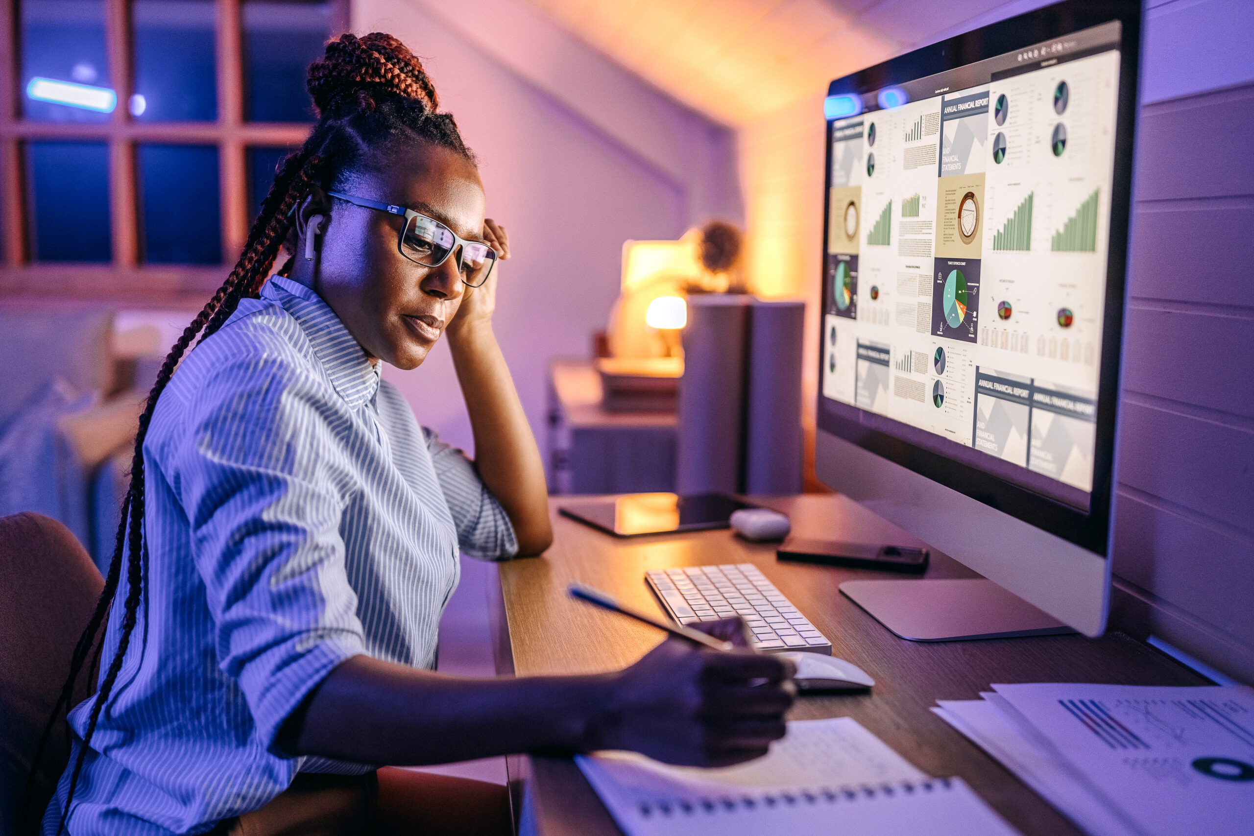 Woman working from home, on her schedule, in front of a large monitor.