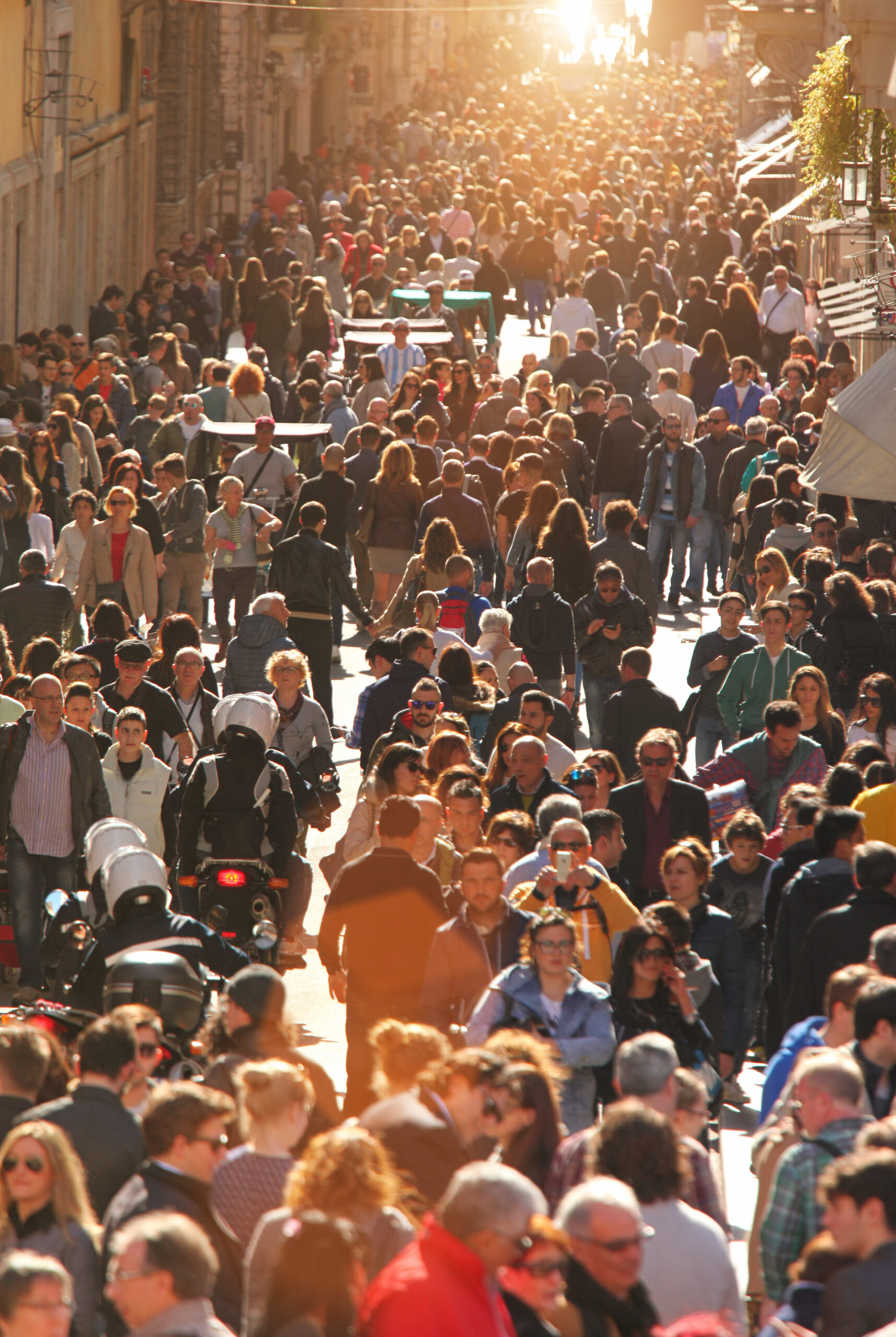 Crowd of people in Rome at sunset.