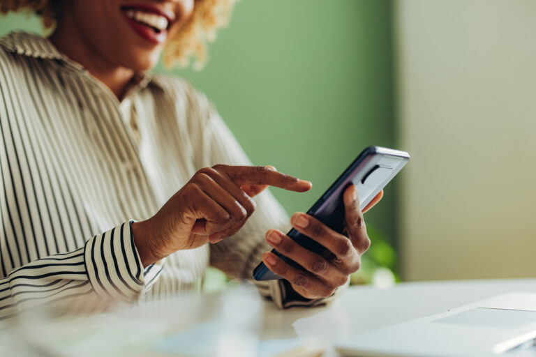 Woman using mobile device seated at a table.