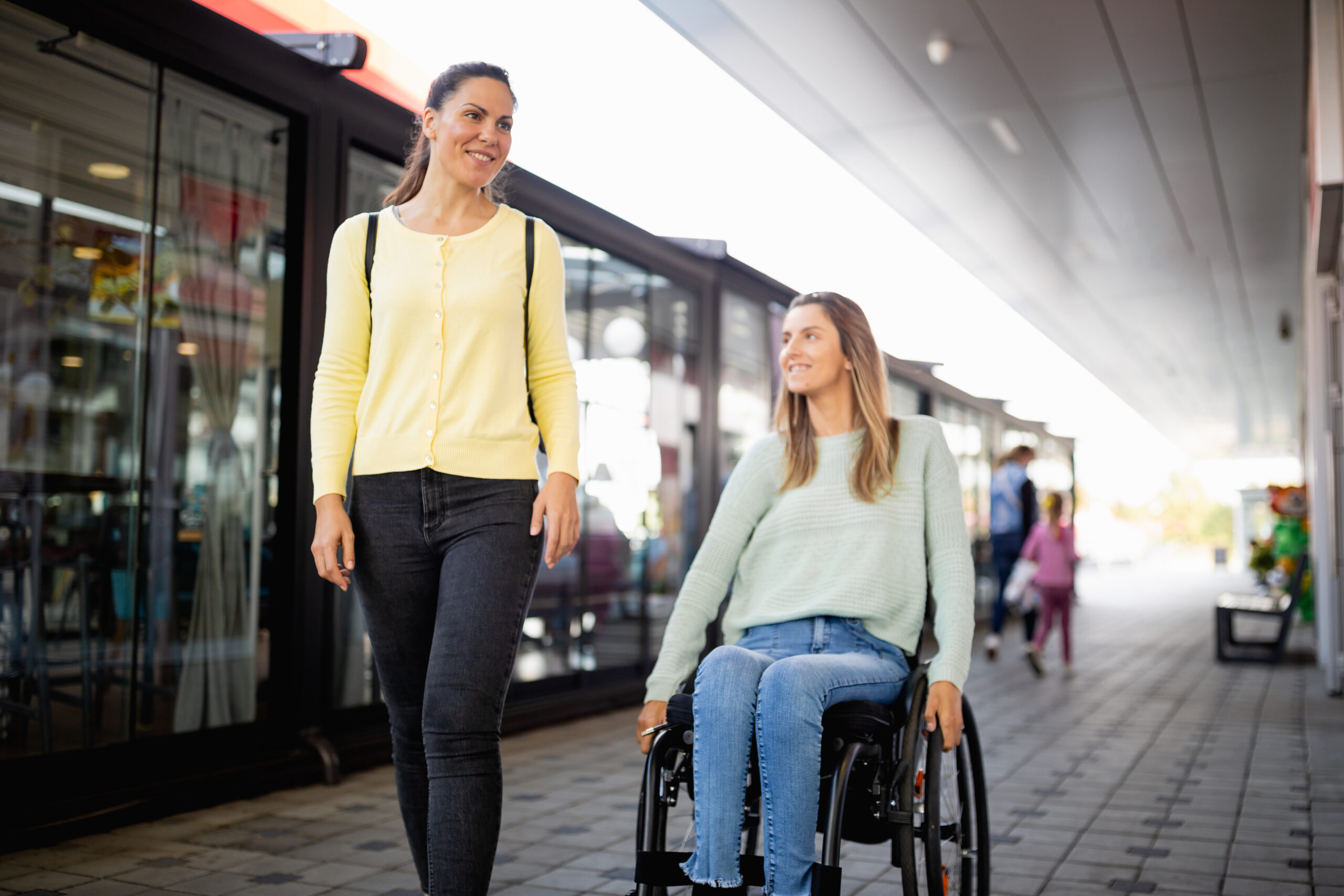 Two women shopping, one woman is using a wheelchair.