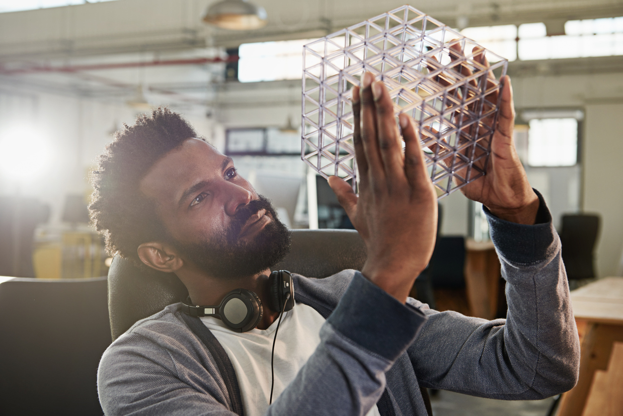 A designer holding up a prototype for inspection.