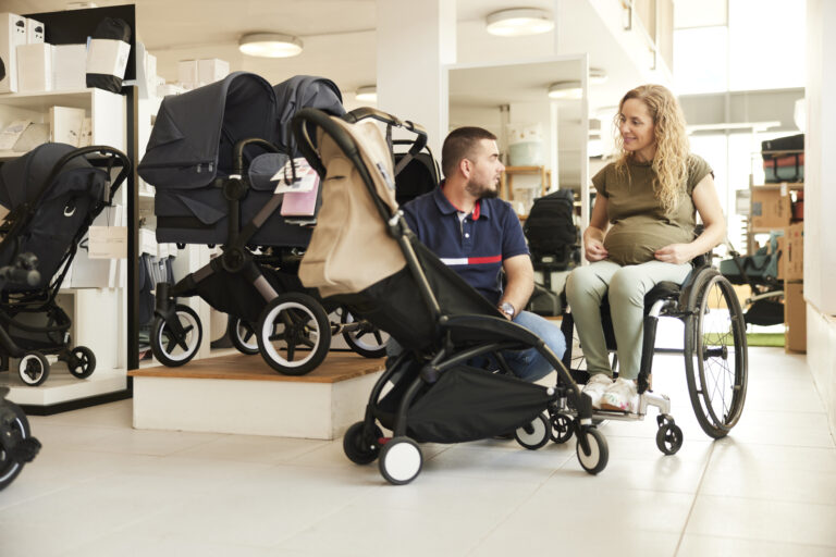 A mom-to-be using her wheelchair, shops with her partner.